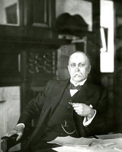William Osler with letters at his desk.