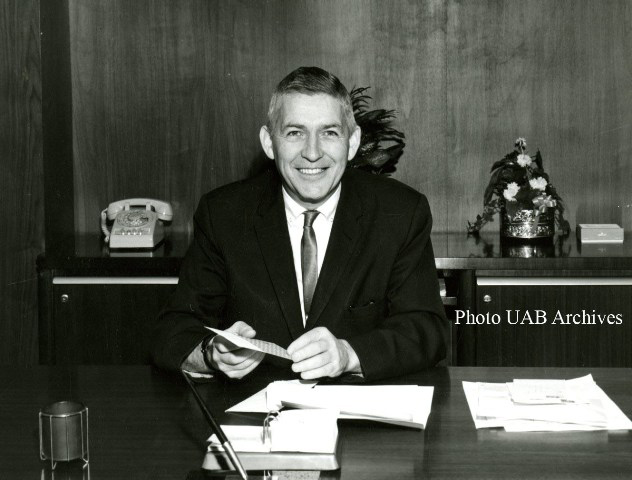 President Volker smiles behind his desk
