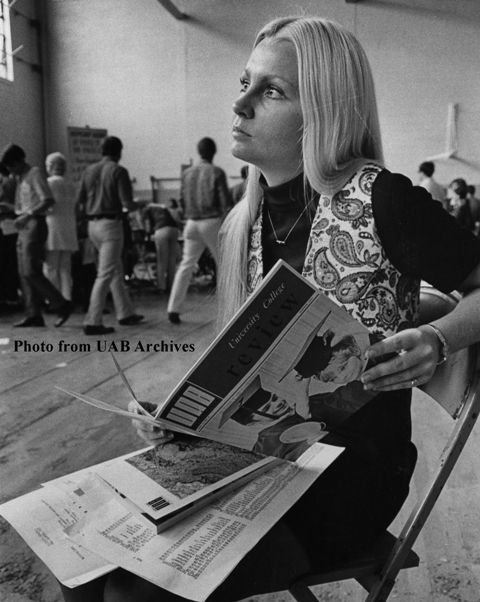 A young female student looks up from a catalog she's holding