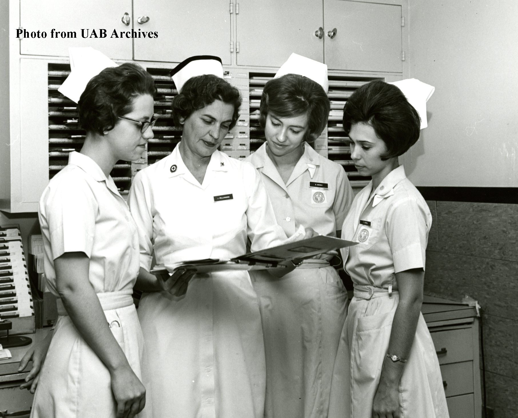 Four female nursing students study a patient chart