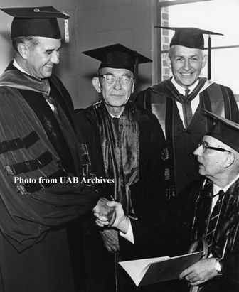 Four men group together in their graduation caps and gowns