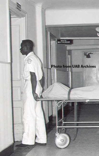An African American hospital worker pulls a gurney into a room