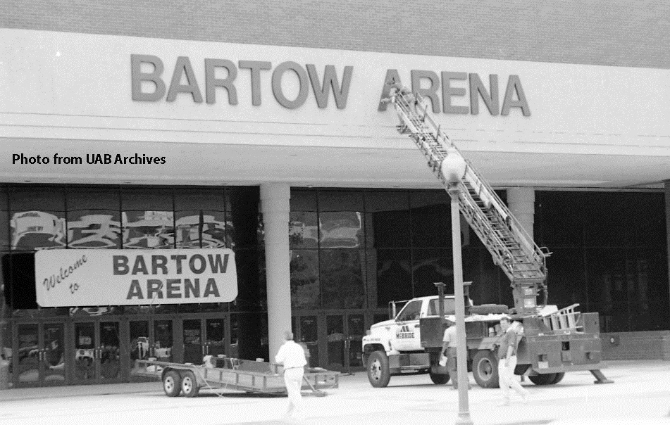 A ladder extends up from a truck to the Bartow Arena sign