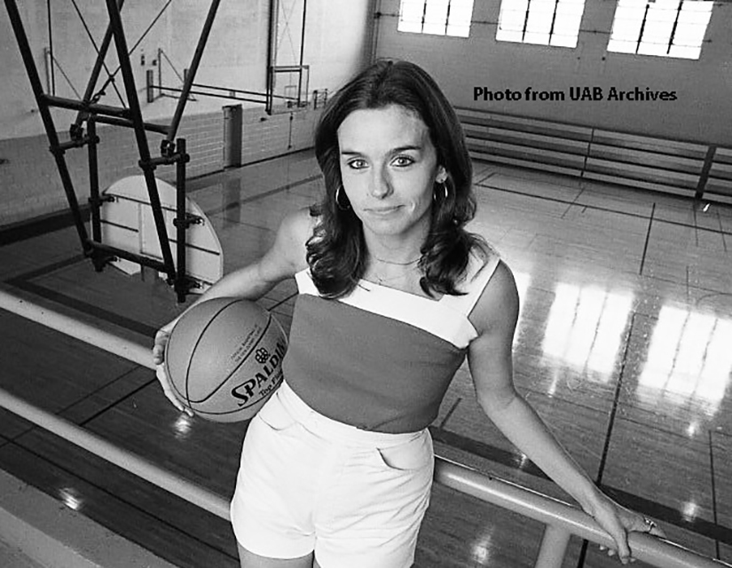 Fran Sharp Merrell poses with a basketball above the court