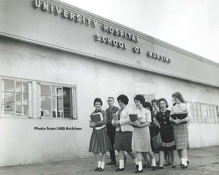 A group of students walk in front of the University Hospital School of Nursing