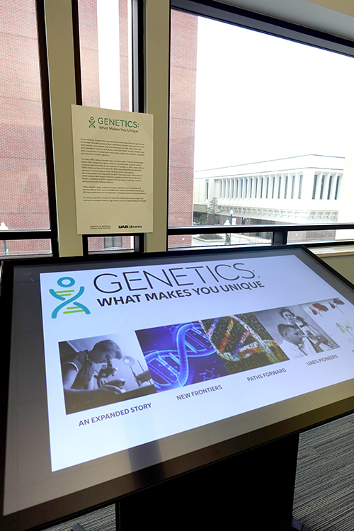 Interactive touchscreen board displays images related to the history of genetics.