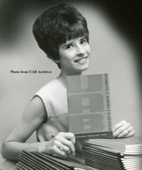 A woman smiles as she holds up a telephone directory